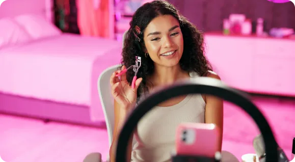 Influencer shooting branded content for a beauty partnership within a relatable space.